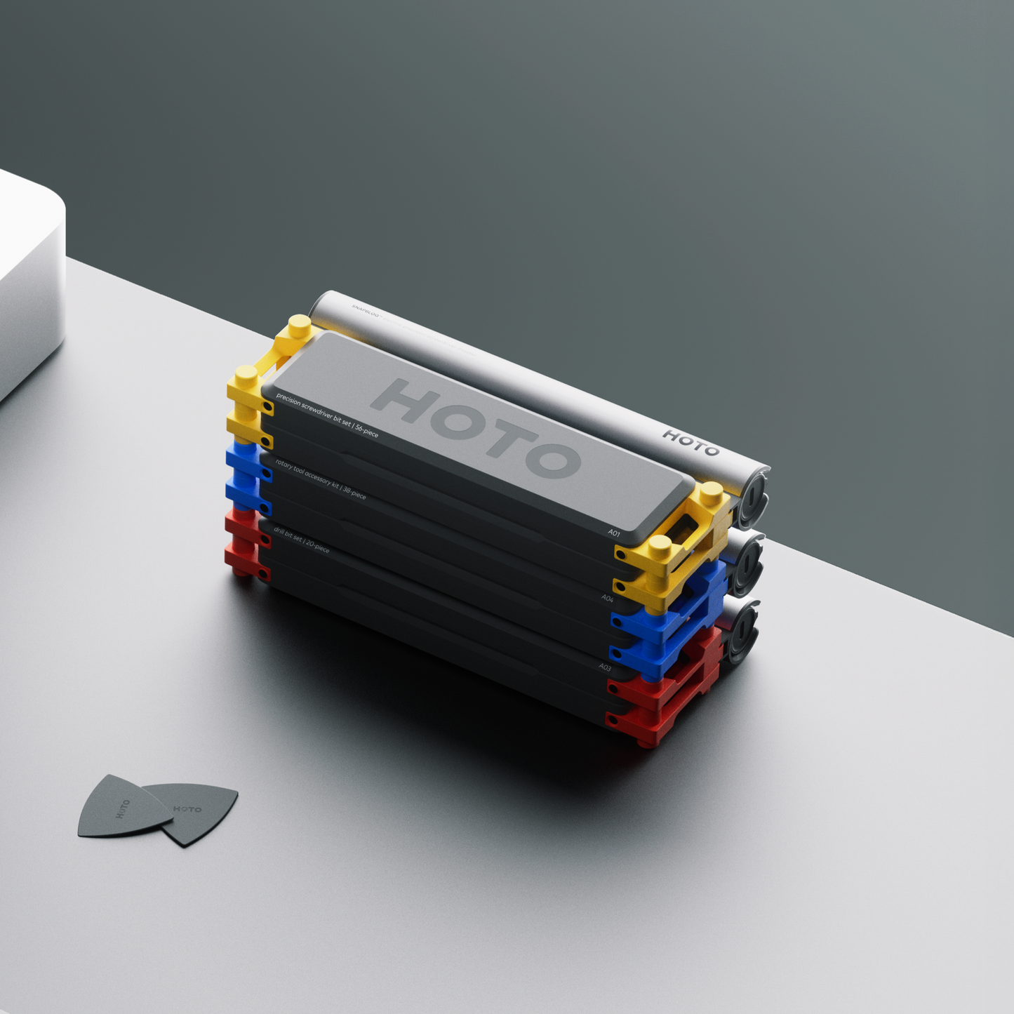Stack of black rectangular blocks with colorful edges on a gray surface, featuring the brand 'HOTO'. HOTO-Snapbloq-module-system-case