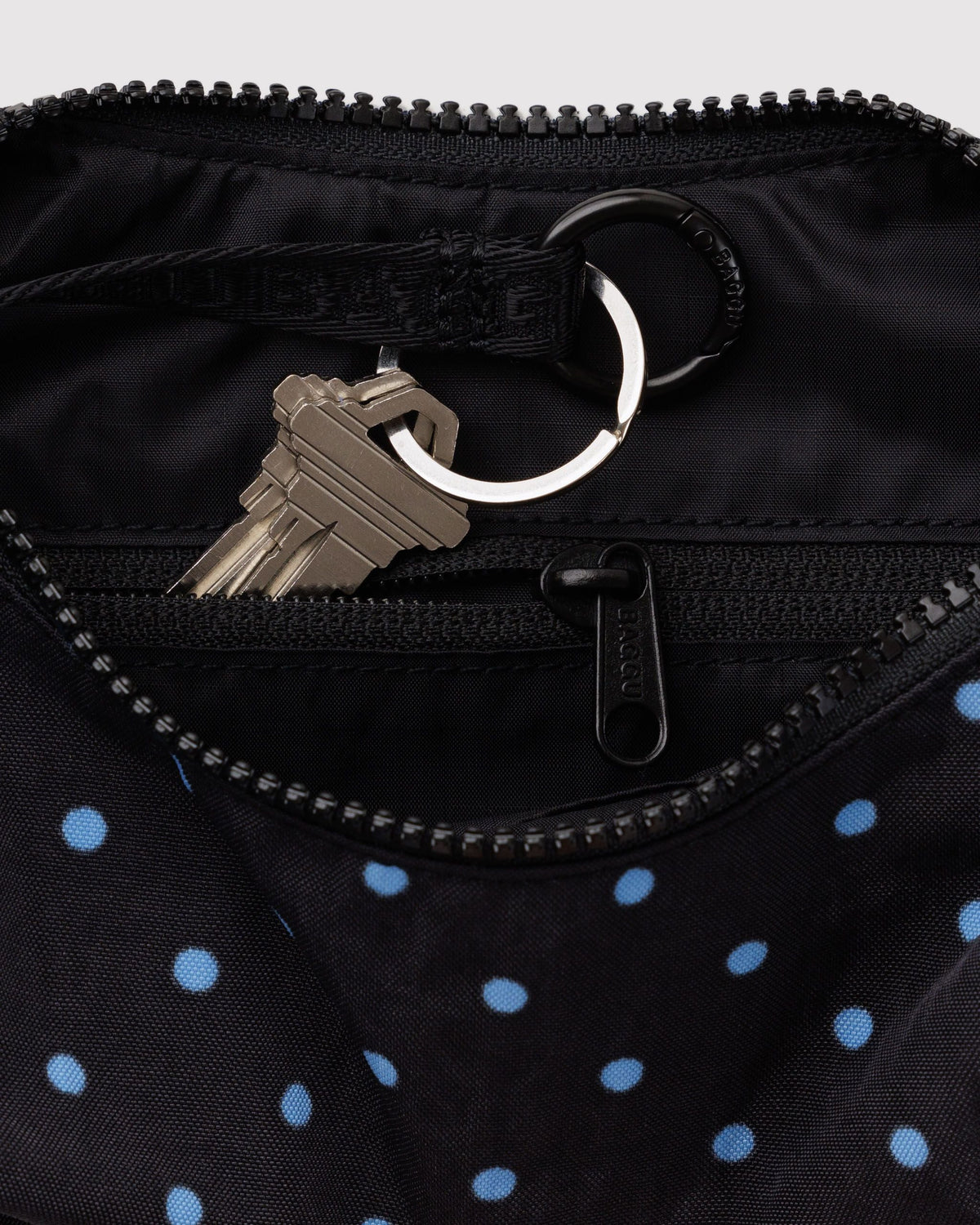 Baggu Small Nylon Crescent Bag in Black and Sky Blue Micro Dot, interior zip pocket and key leash detail | Black and Sky Blue Micro Dot