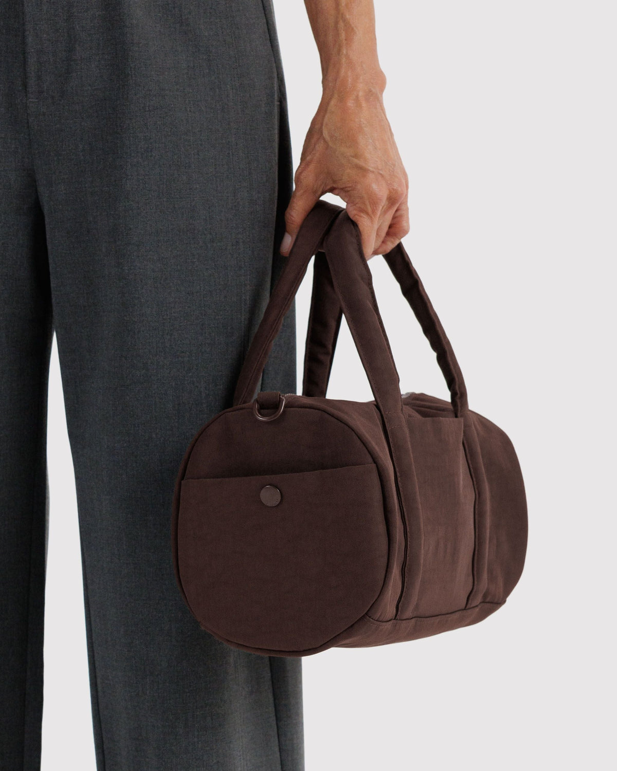 BAGGU Nylon Duffle Bag in Coffee, carried by the padded handles | Coffee