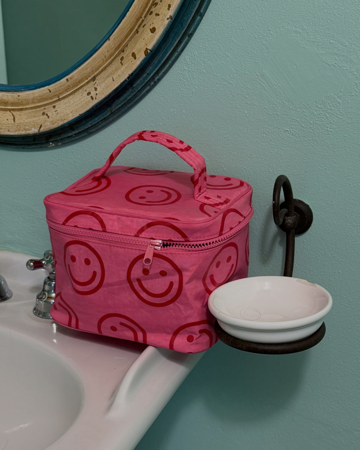BAGGU Large Cosmetic Case in Azalea Pink Happy, on a bathroom shelf | Azalea Pink Happy