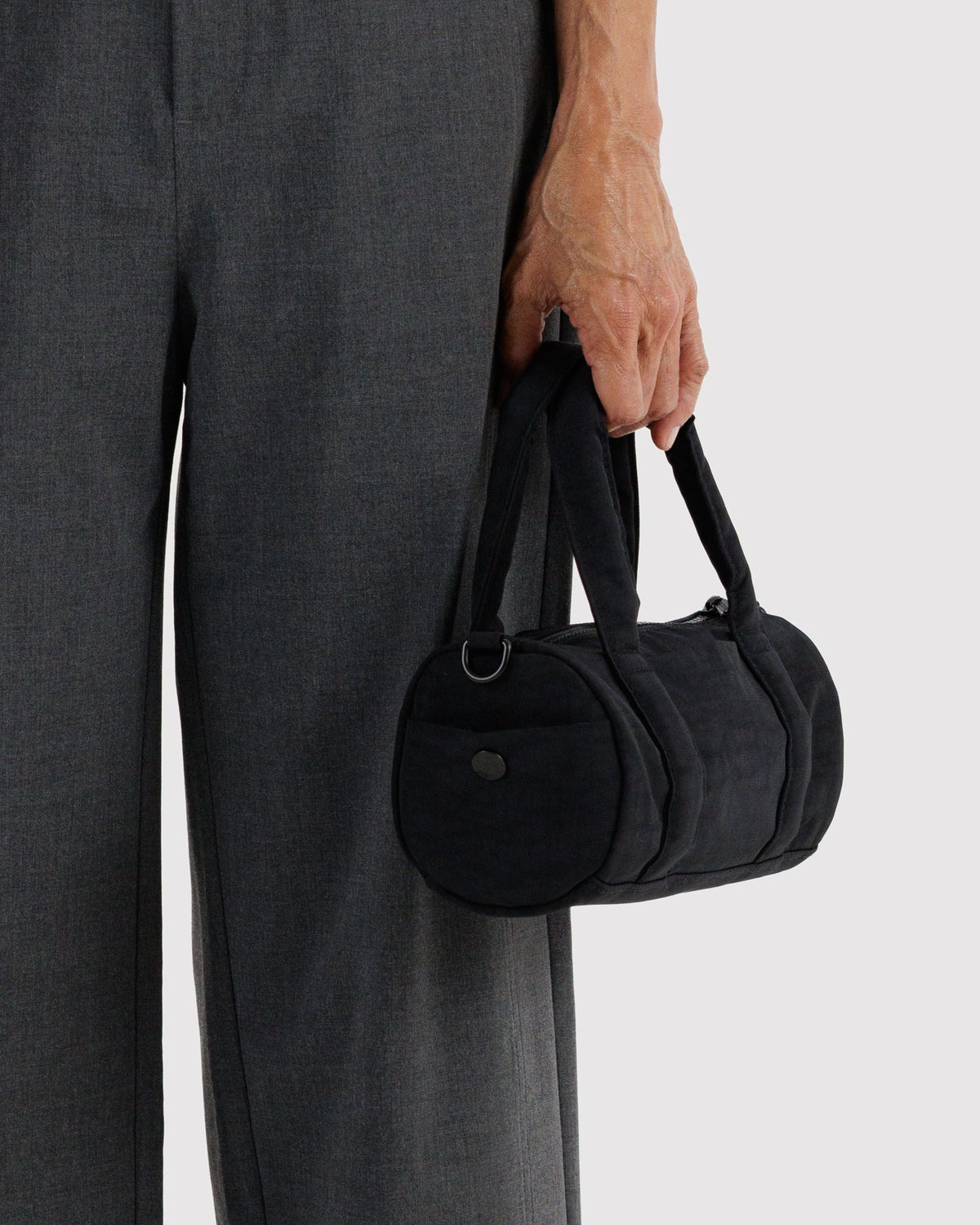 BAGGU Small Nylon Duffle Bag in Black, carried by the padded handles | Black