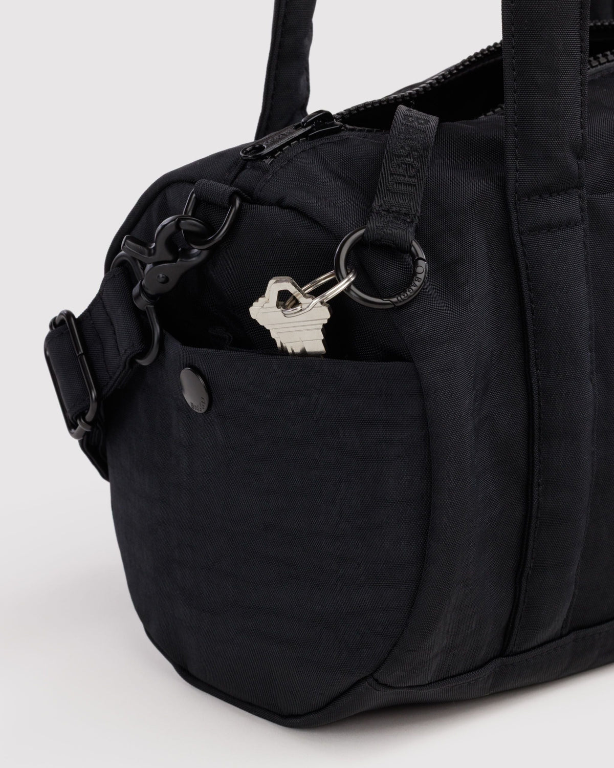 BAGGU Nylon Duffle Bag in Black, side pocket and key leash detail | Black