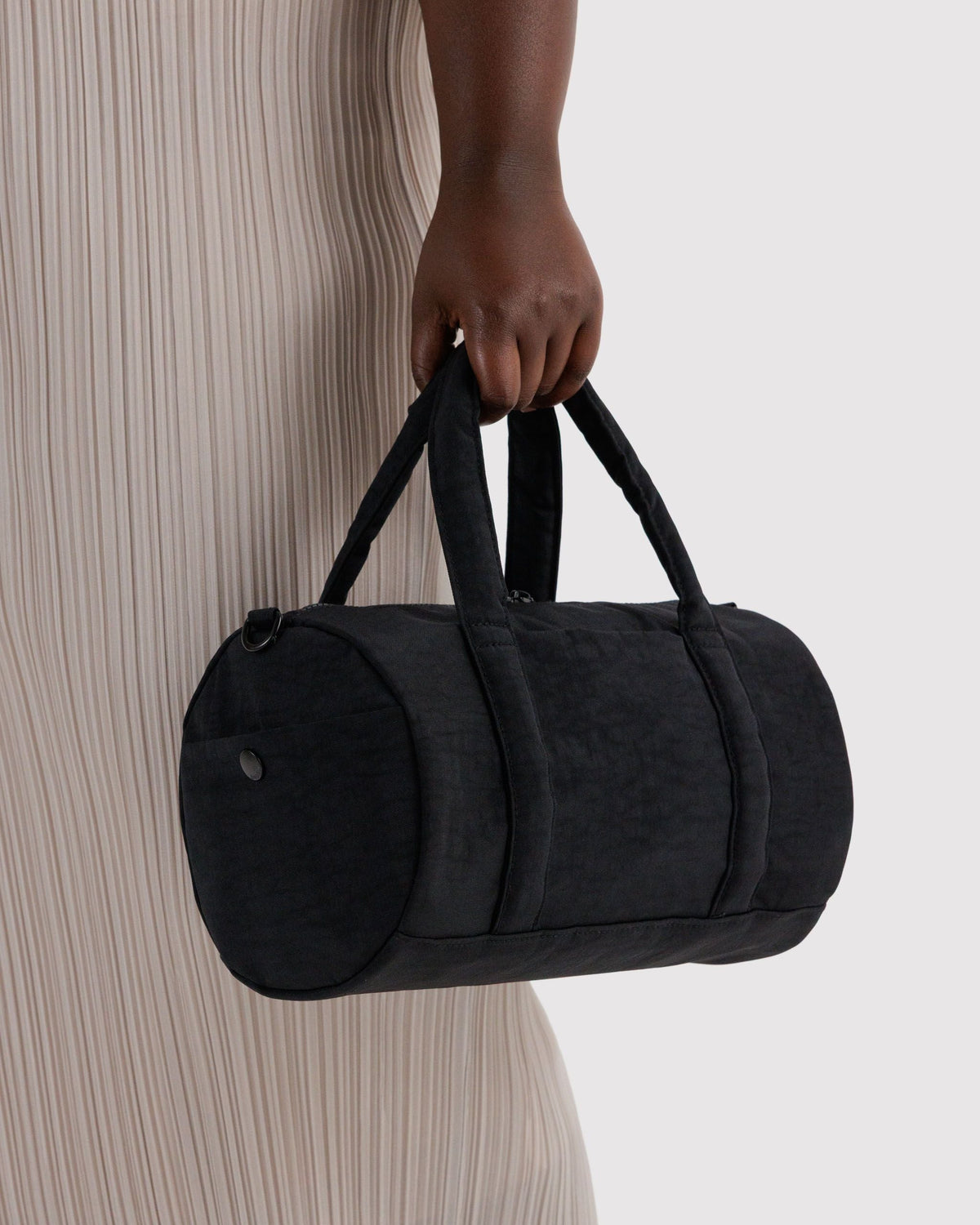 BAGGU Nylon Duffle Bag in Black, carried by the padded handles | Black
