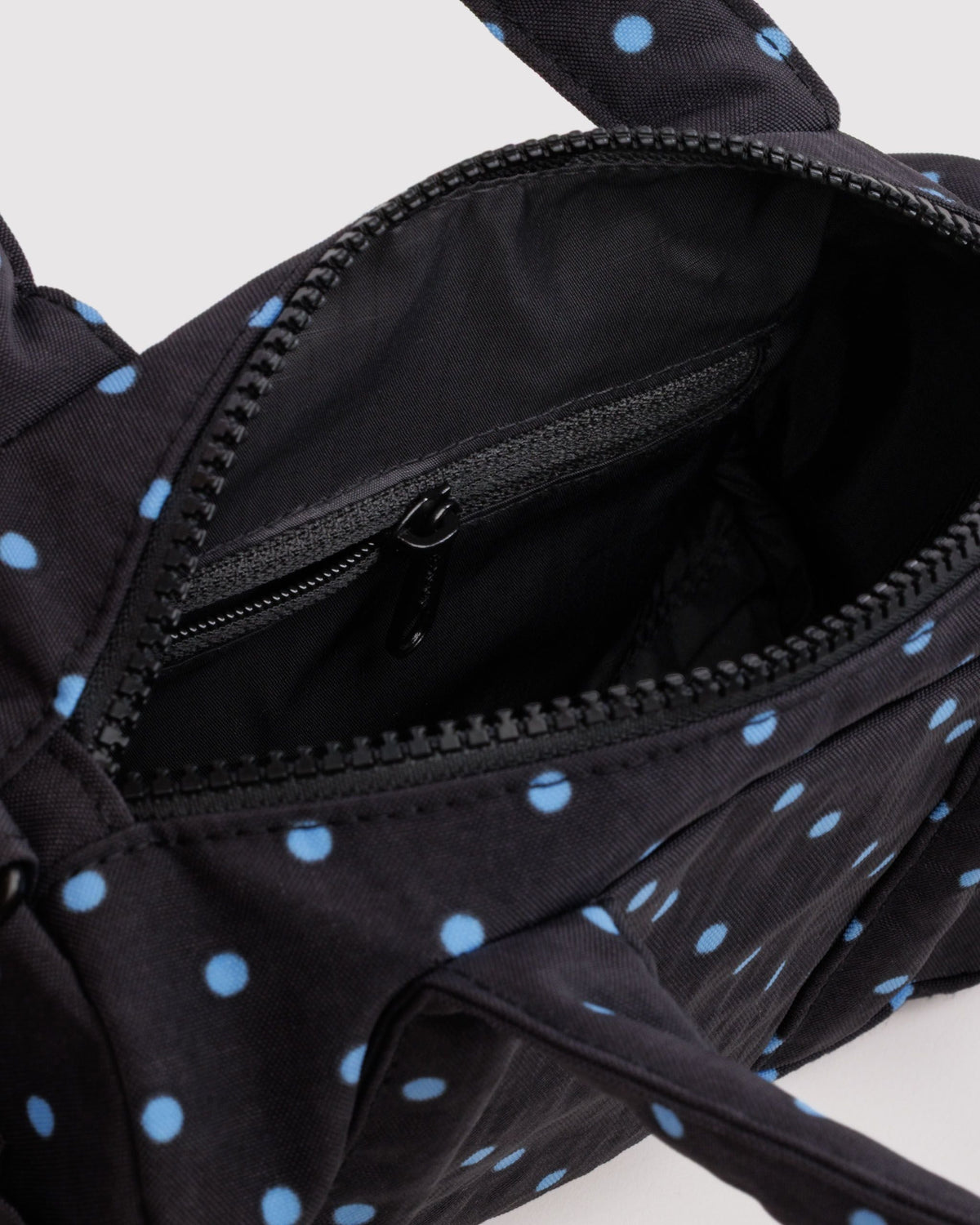 BAGGU Small Nylon Duffle Bag in Black and Sky Blue Micro Dot, interior zip pocket detail | Black and Sky Blue Micro Dot