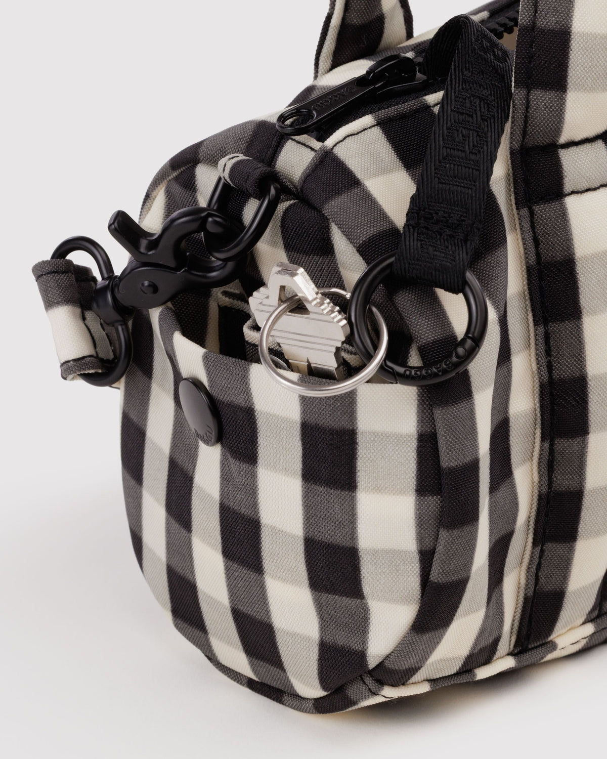 BAGGU Small Nylon Duffle Bag in Black and Cream Gingham, side pocket and key leash detail | Black and Cream Gingham