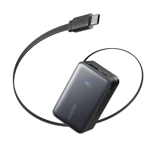 Anker Nano power bank in black, angled to show its display, top ports and built-in USB-C connector extended on its cable.