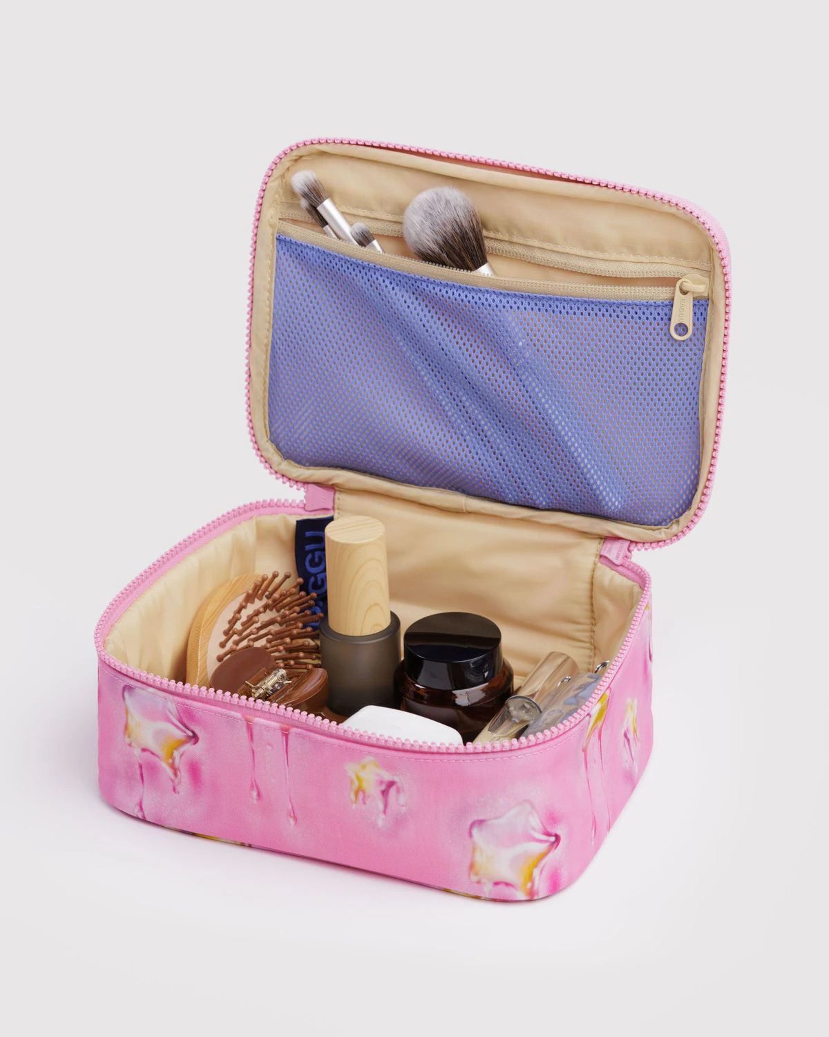 Pink cosmetic bag with makeup items on a light gray background Baggu Small Cosmetic Case | Dancing Star