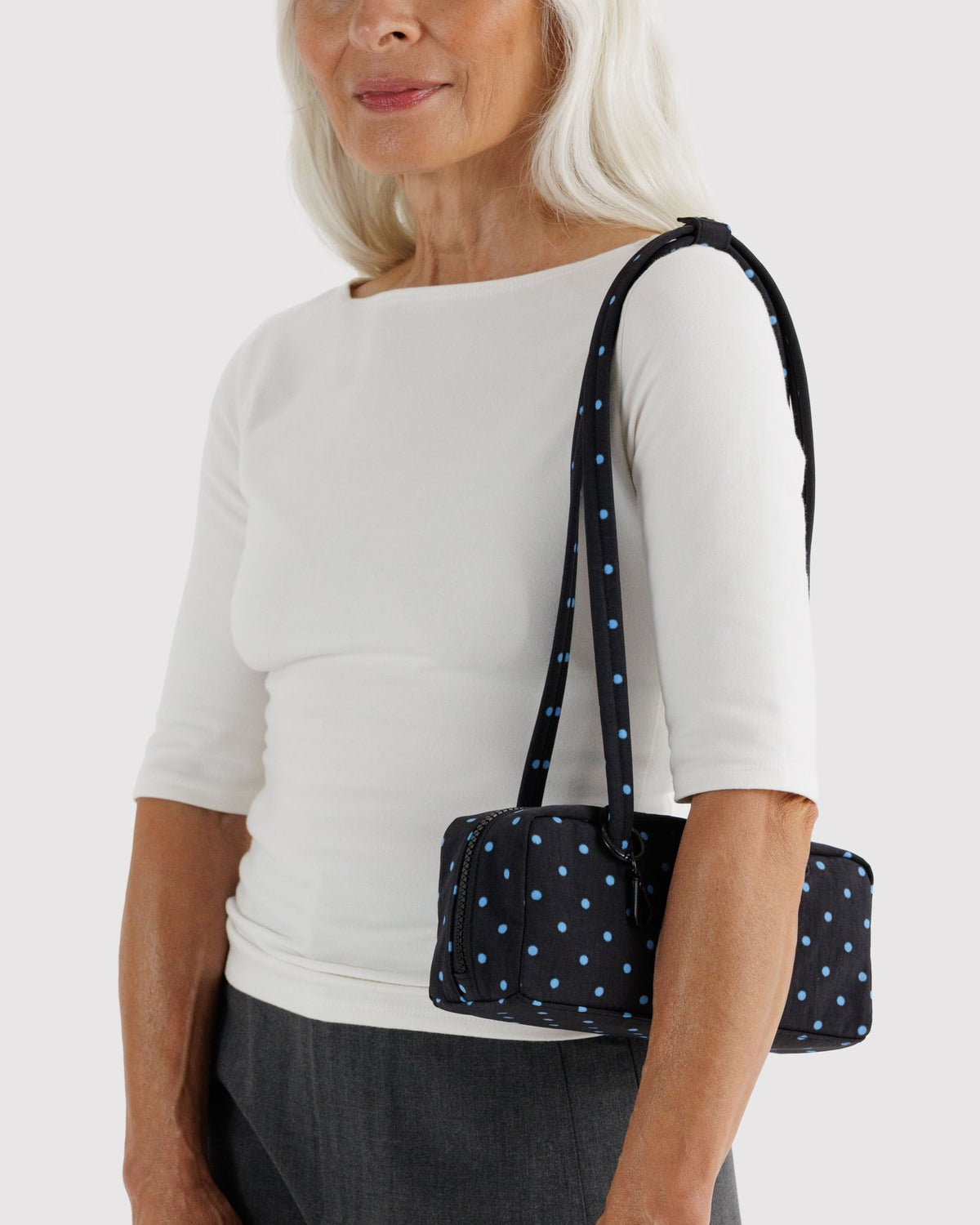 Baggu Small Nylon Bowler Bag worn over the shoulder | Black and Sky Blue Micro Dot
