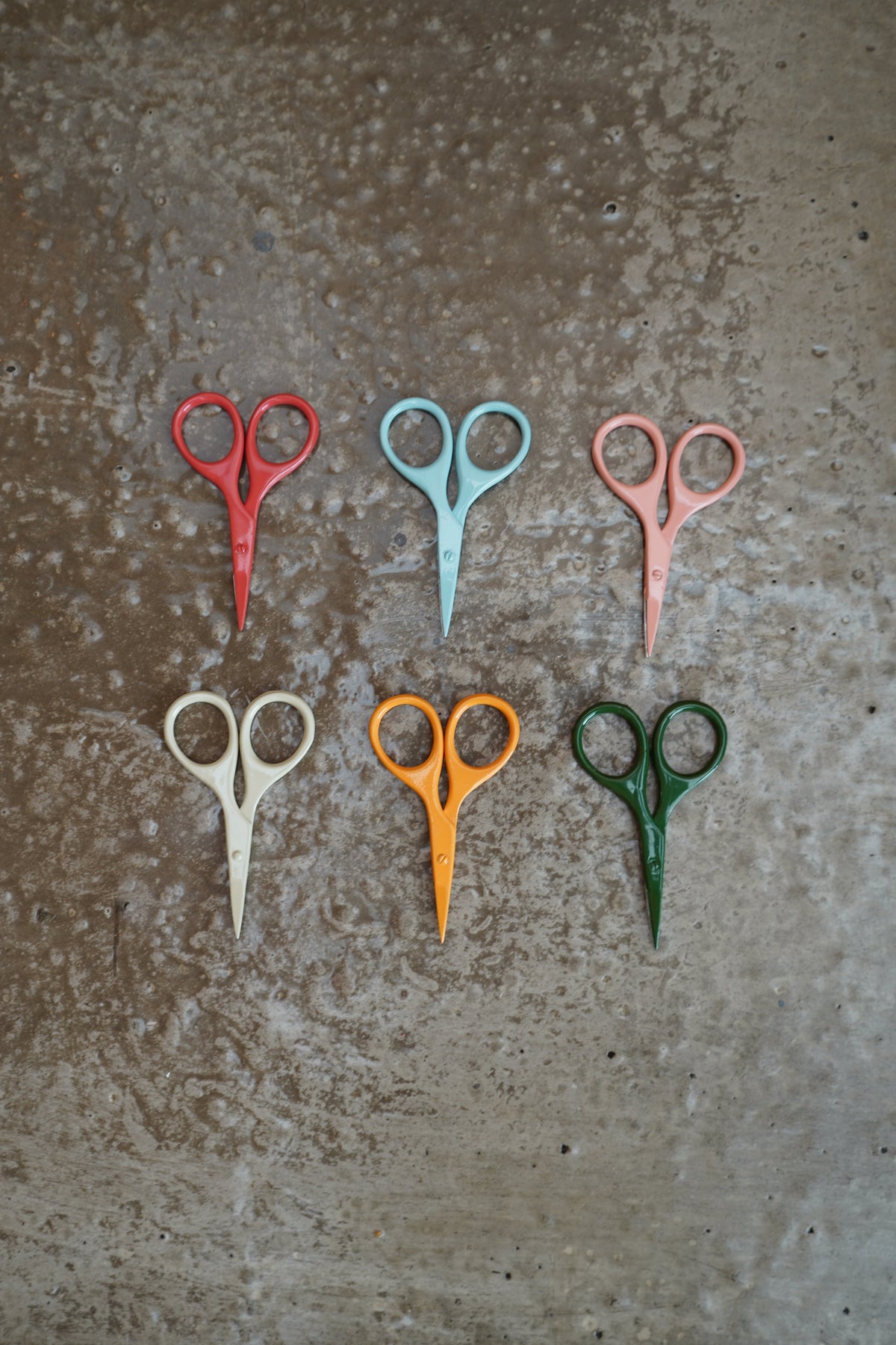 Six colorful DEGEN Mini Scissors arranged on a textured surface, including golden-yellow Koi and deep-green Tree | Koi, Tree