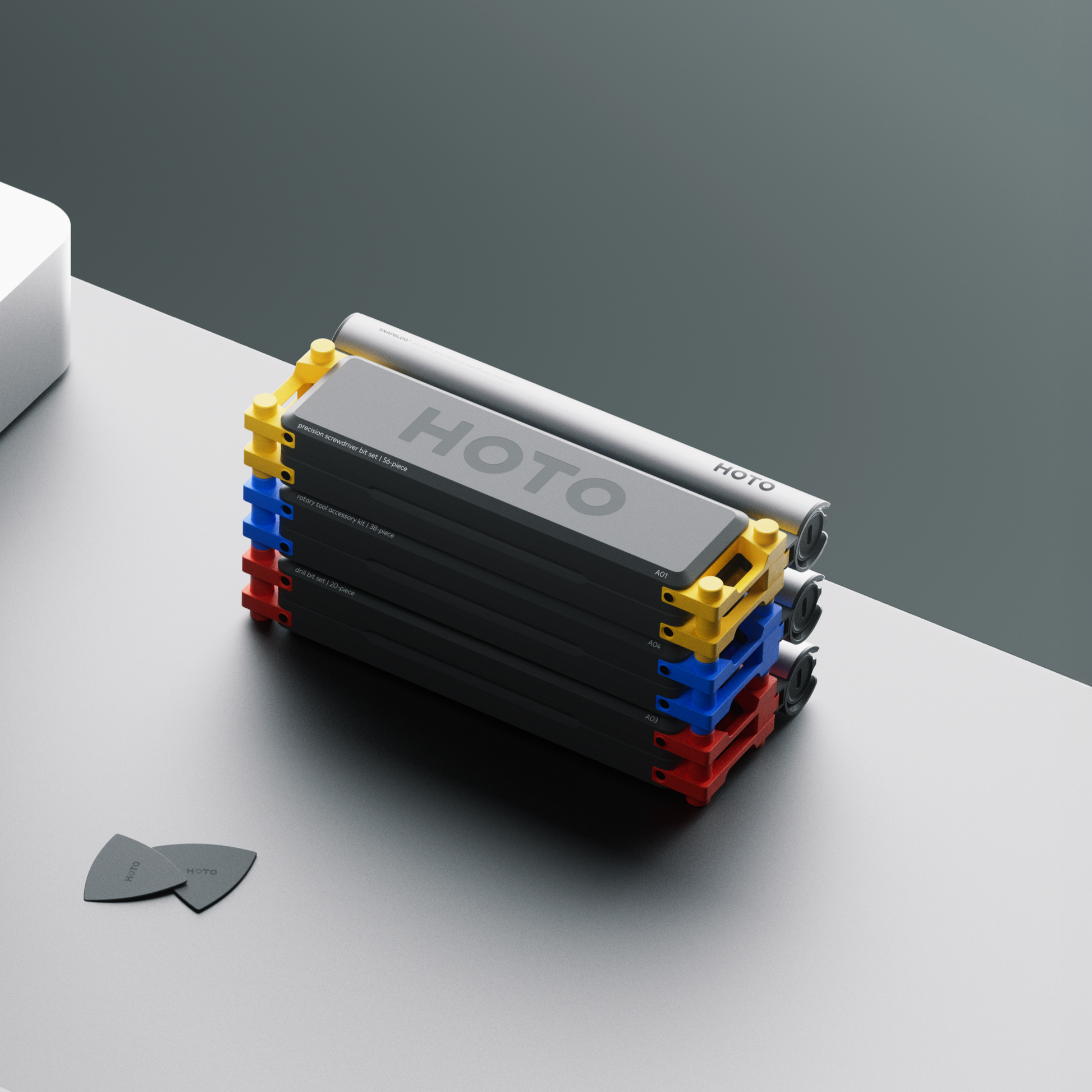 Stack of black rectangular blocks with colorful edges on a gray surface, featuring the brand 'HOTO'. HOTO-Snapbloq-module-system-case