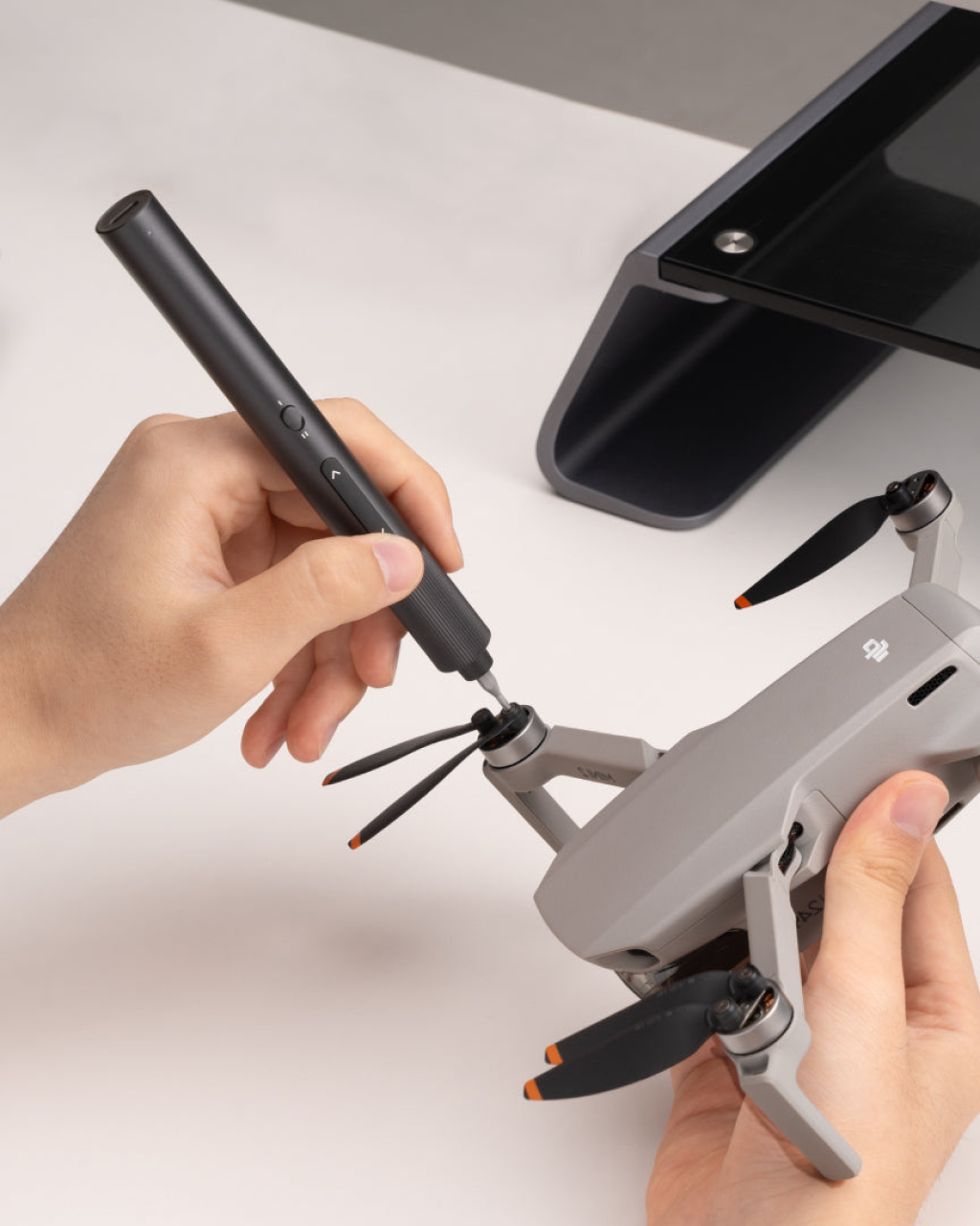 Person using a tool to adjust a drone on a white surface HOTO Electric Precision Screwdriver ADV