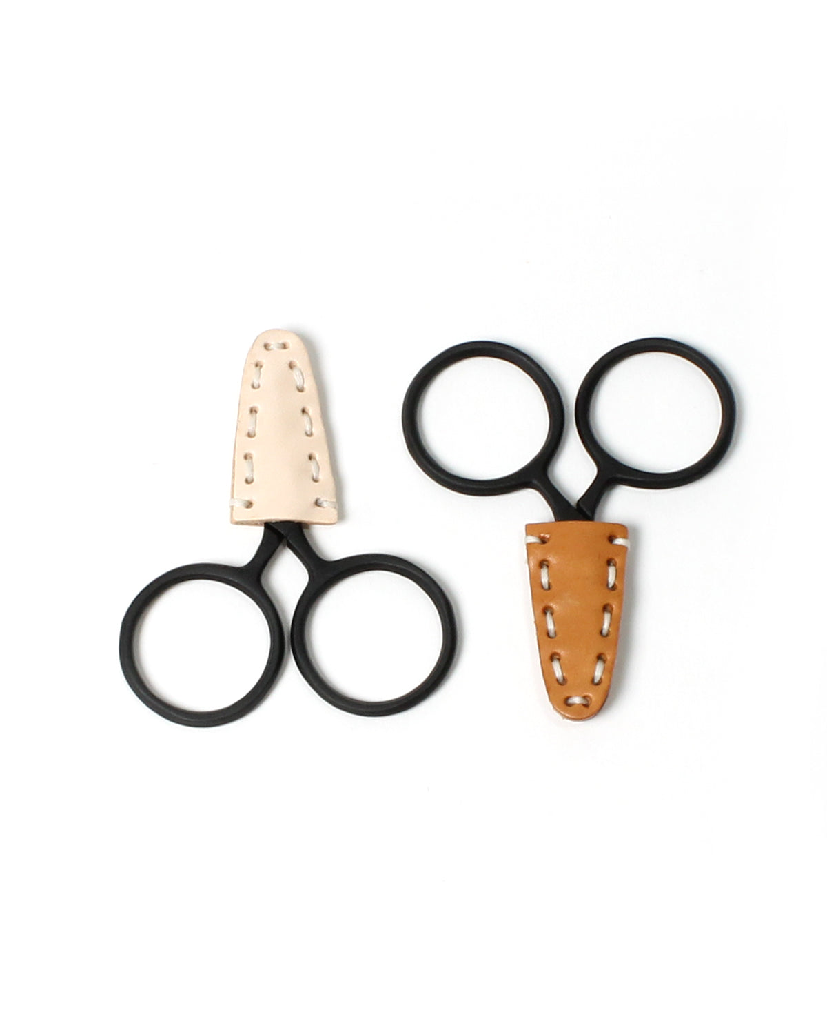 DEGEN Light natural and darker tan leather scissor tip protectors fitted to black round-handled scissors