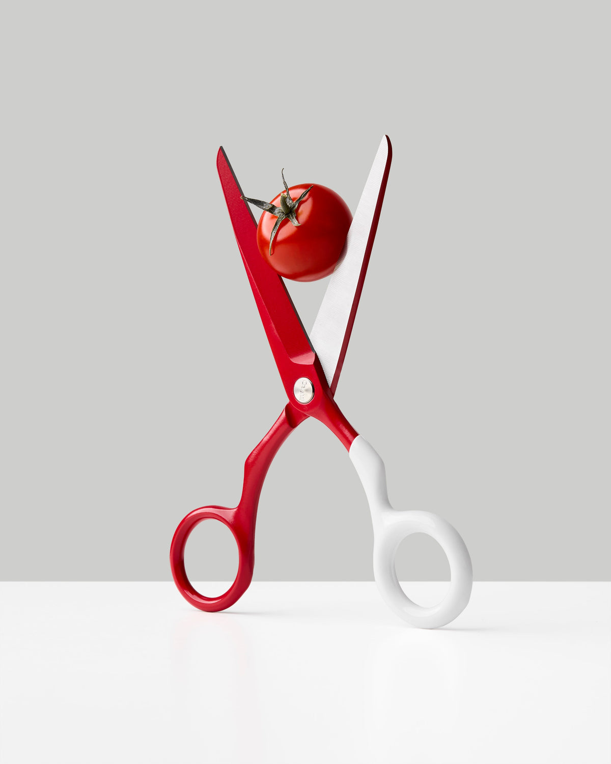 Craighill Spectra Scissors in Red + White, shown open with a small tomato between the blades | Red + White