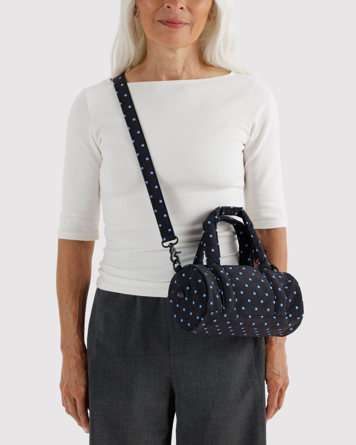 BAGGU Small Nylon Duffle Bag in Black and Sky Blue Micro Dot, worn crossbody | Black and Sky Blue Micro Dot