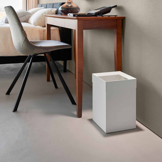 White Yamazaki Tower short steel trash can beside a separate wooden desk and chair