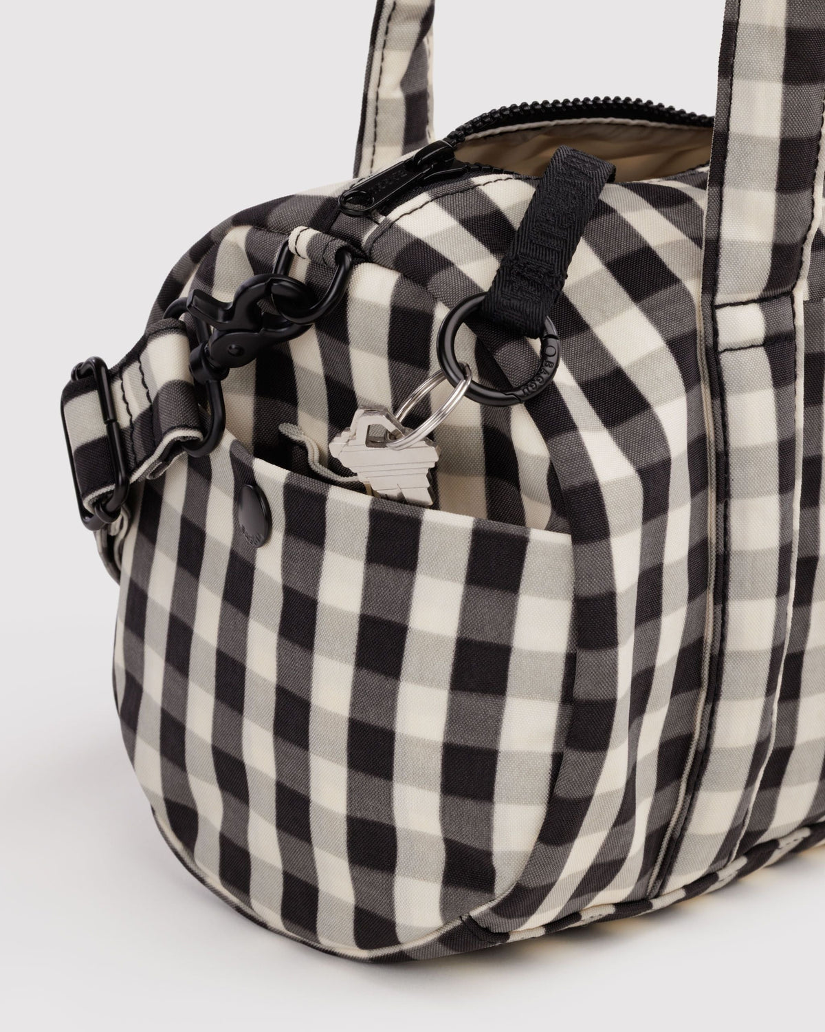 BAGGU Nylon Duffle Bag in Black and Cream Gingham, side pocket and key leash detail | Black and Cream Gingham