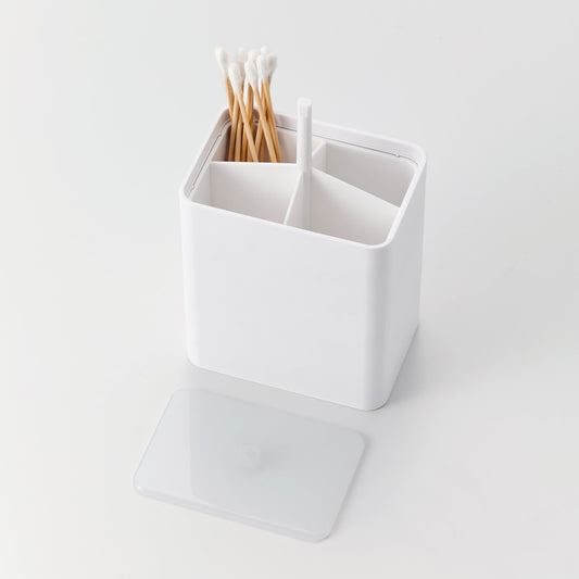 White cotton swab case with the lid removed, showing divided storage and cotton swabs in one compartment.