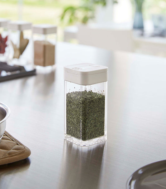 Yamazaki Home Tower Sliding-Lid Spice Jar - White, 120 ml, white-lidded jar filled with dried herbs on counter