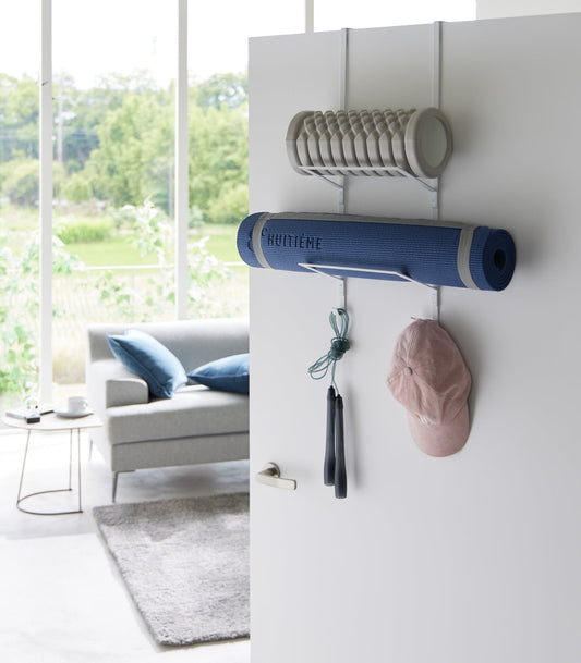 Yamazaki Home Tower Over-the-Door Fitness Equipment Hanger, white hanger holding yoga mat foam roller and accessories on door