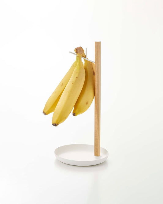 Yamazaki Home Tosca Banana Stand - Steel + Wood, white and wood stand holding bananas on a plain background