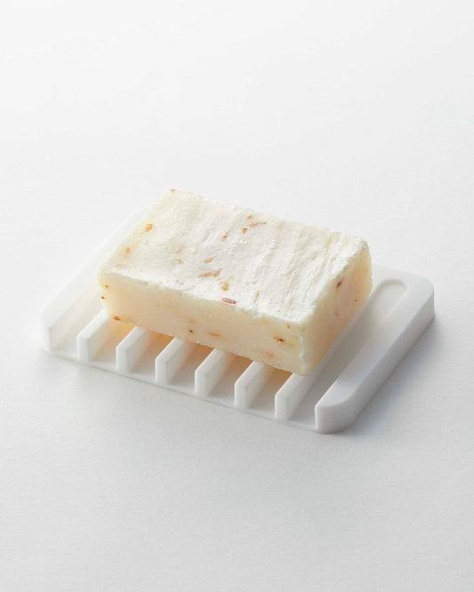 Yamazaki Home Flow Self-Draining Soap Tray - Silicone, white grooved tray holding a bar of soap