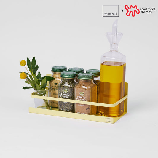 Yamazaki Home Magnetic Storage Caddy - Yellow Pear — Yellow Pear caddy with spices and oil, showing Yamazaki x Apartment Therapy collaboration logos.