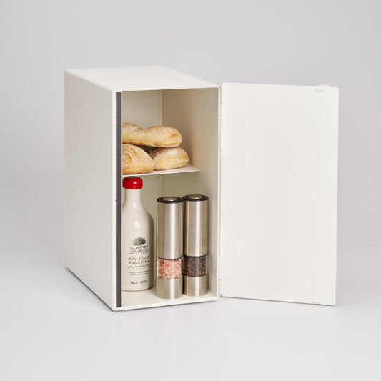 White Yamazaki Tosca vertical bread box with its wood-handled door open, showing separate bread, a bottle and spice containers on two levels.